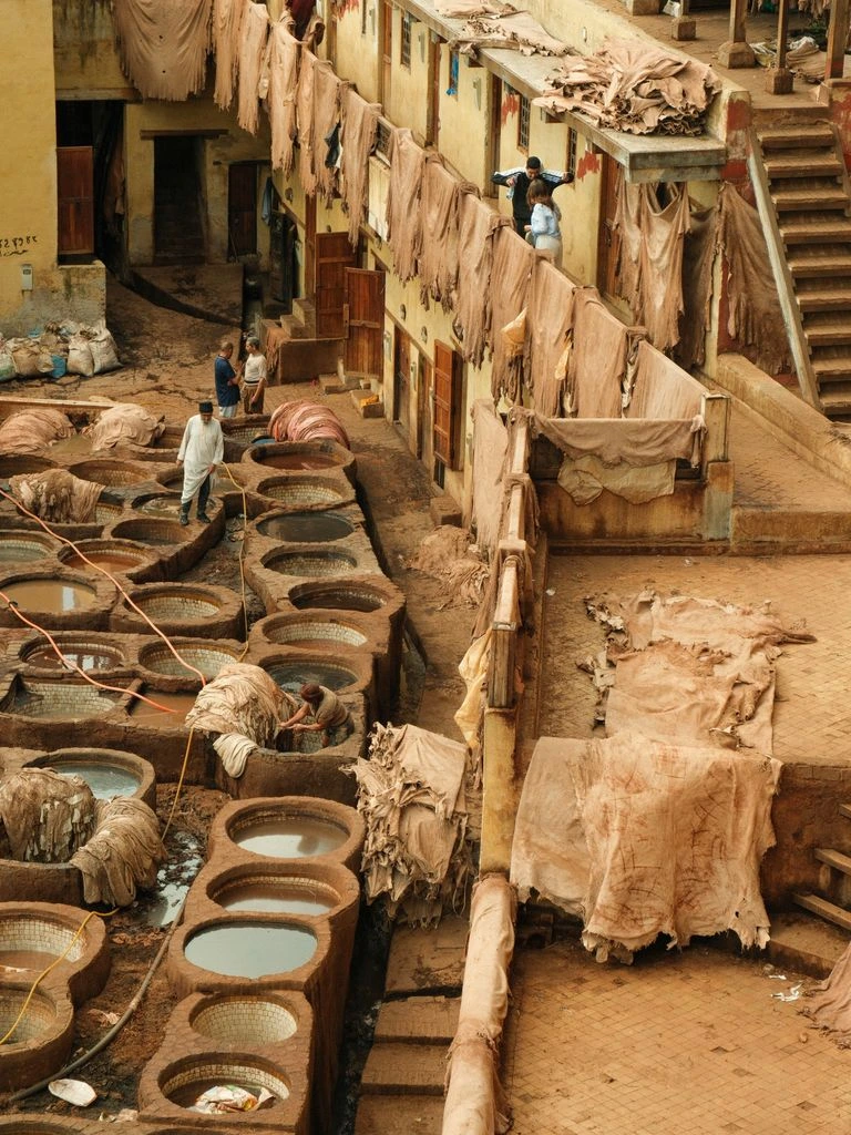 A craftsman stirs a tanning pit at Conceria Walpier.